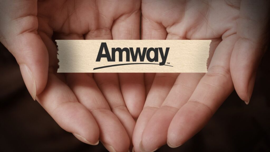 duas mão segurando gentilmente um fita adesiva com a logo da amway